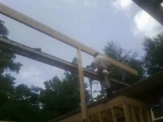 Carpenter setting a ridge beam over a new addition frame — Ice Dam Removal by Roofing Brothers in Fish Haven