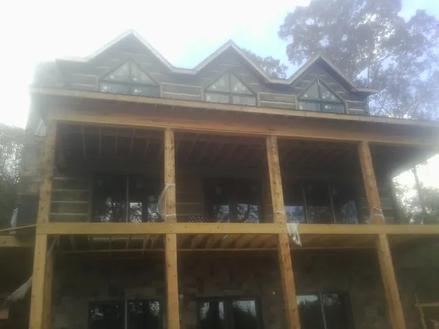 Dormers and porch framing on a large log home under construction — Roof Coating work by our crew in Fish Haven