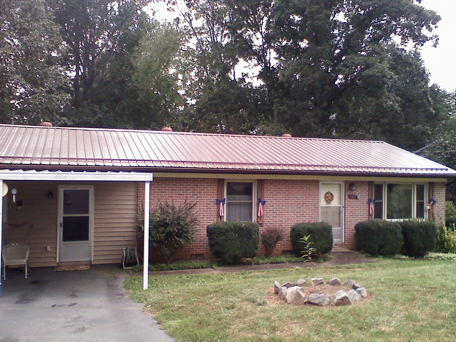 Bronze metal roof and carport on a brick ranch home — Roof Repair work by our crew in Fish Haven